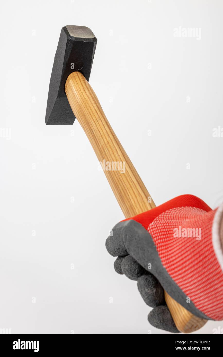 Männerhand mit Arbeitshandschuh, der einen Schlosserhammer hält, weißer Hintergrund, Stockfoto