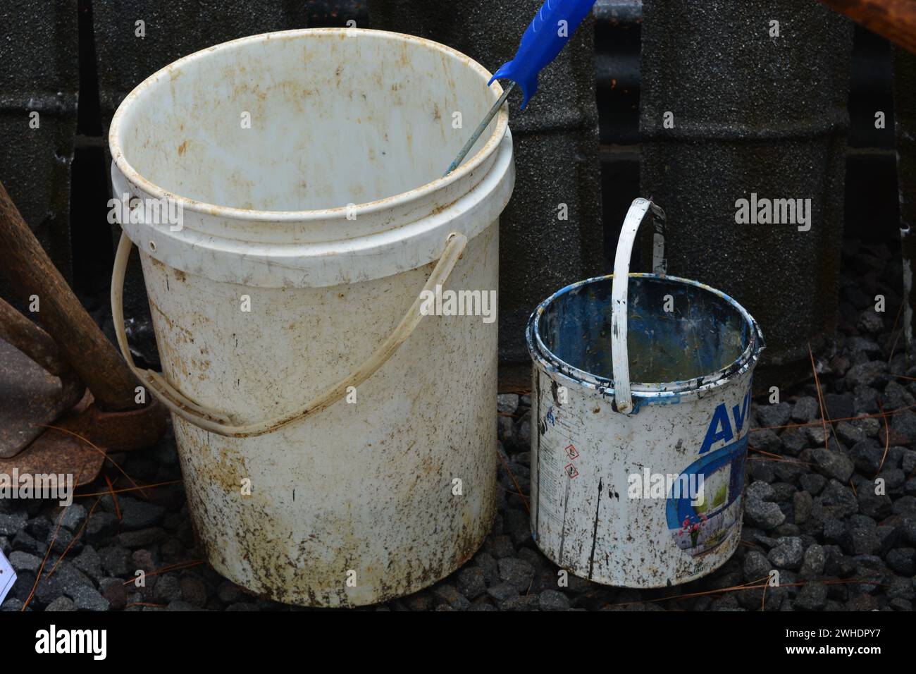 Ein großer Eimer und ein kleiner Eimer mit gebrauchter Farbe auf dem Boden. Stockfoto