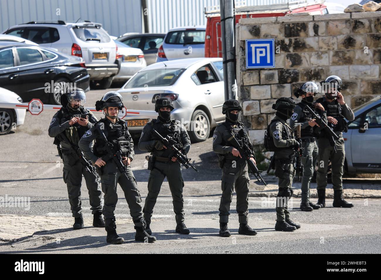 Jerusalem, Israel. Februar 2024. Mitglieder der israelischen Sicherheitskräfte stehen während des Freitagmittagsgebet am Kontrollpunkt nahe dem Löwentor in Jerusalem während der anhaltenden Kämpfe zwischen Israel und der palästinensischen Gruppe Hamas auf Wache. Die israelischen Streitkräfte ergreifen Sicherheitsmaßnahmen, während die Palästinenser Freitagsgebet auf einer Straße im Stadtteil Ras Al-Amud in Jerusalem verrichten. Quelle: SOPA Images Limited/Alamy Live News Stockfoto