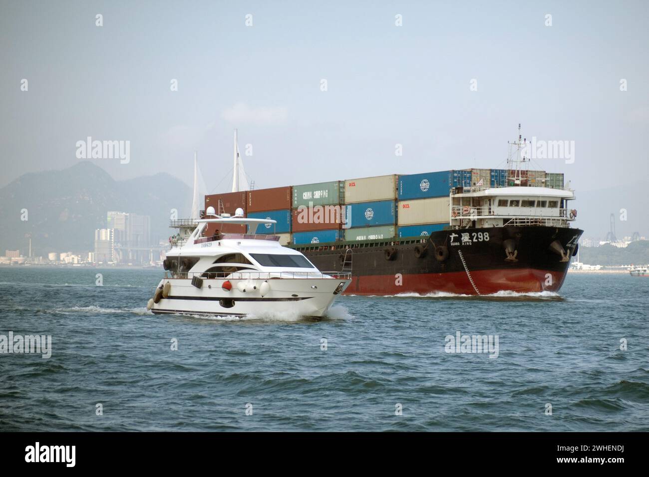 '09.12.2023, China, Hongkong, Hongkong - das Motorboot überholt ein Containerschiff im Südchinesischen Meer. 00S231209D194CAROEX.JPG [MODELLVERSION: NICHT AP Stockfoto
