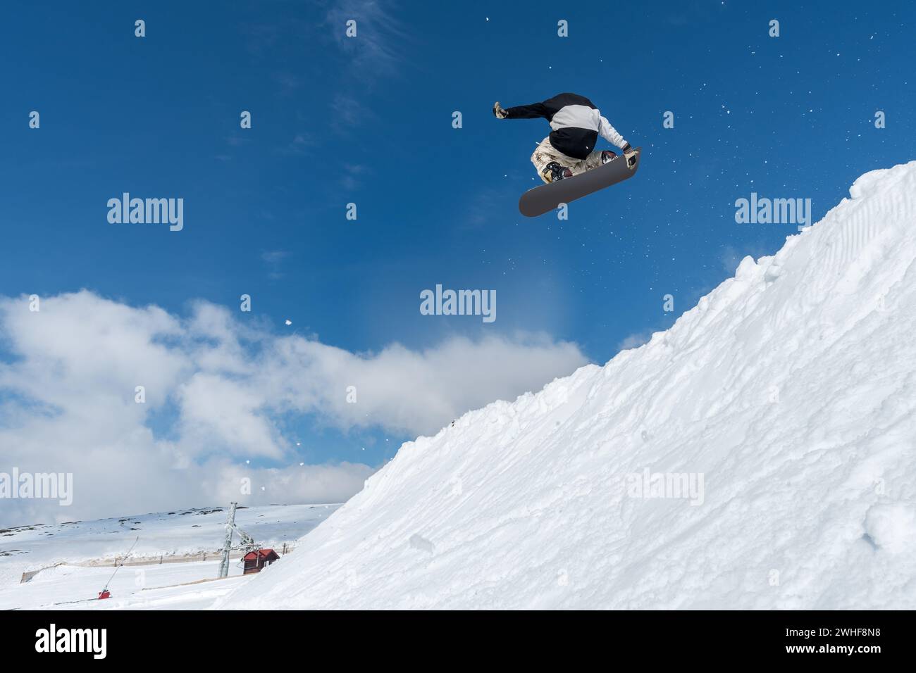 Snowboarder springt gegen blauen Himmel Stockfoto