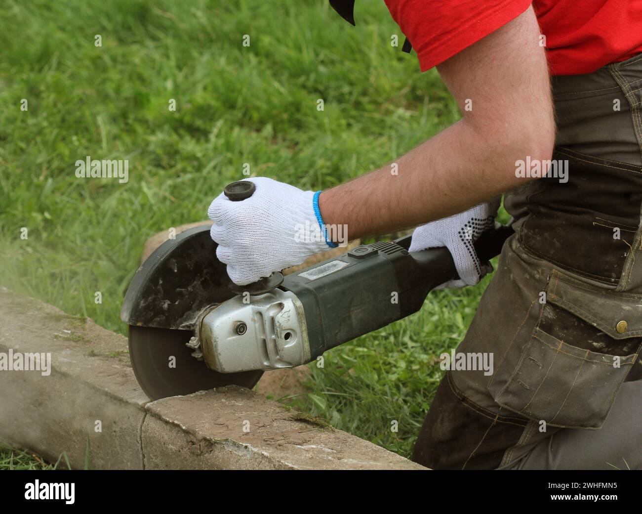 Bauarbeiter schneiden Betonplatte für Zaun Stiftung mit einem Cut-off-sah Stockfoto