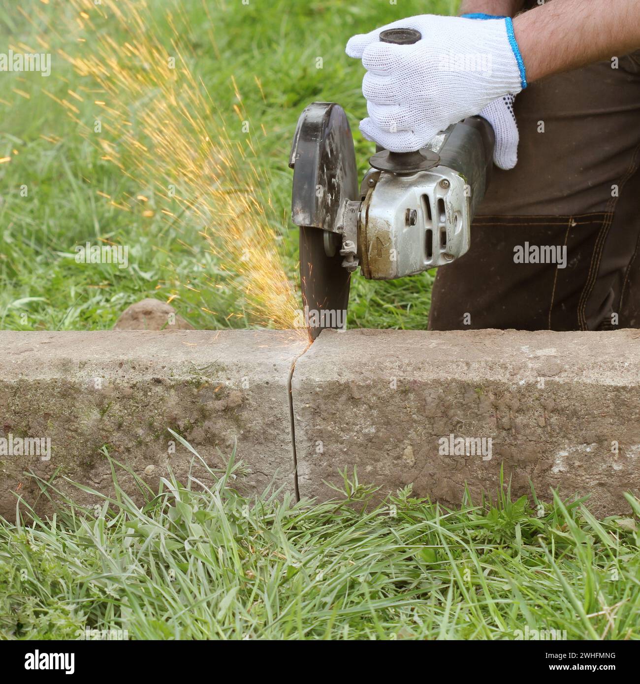 Bauarbeiter schneiden Betonplatte für Zaun Stiftung mit einem Cut-off-sah Stockfoto