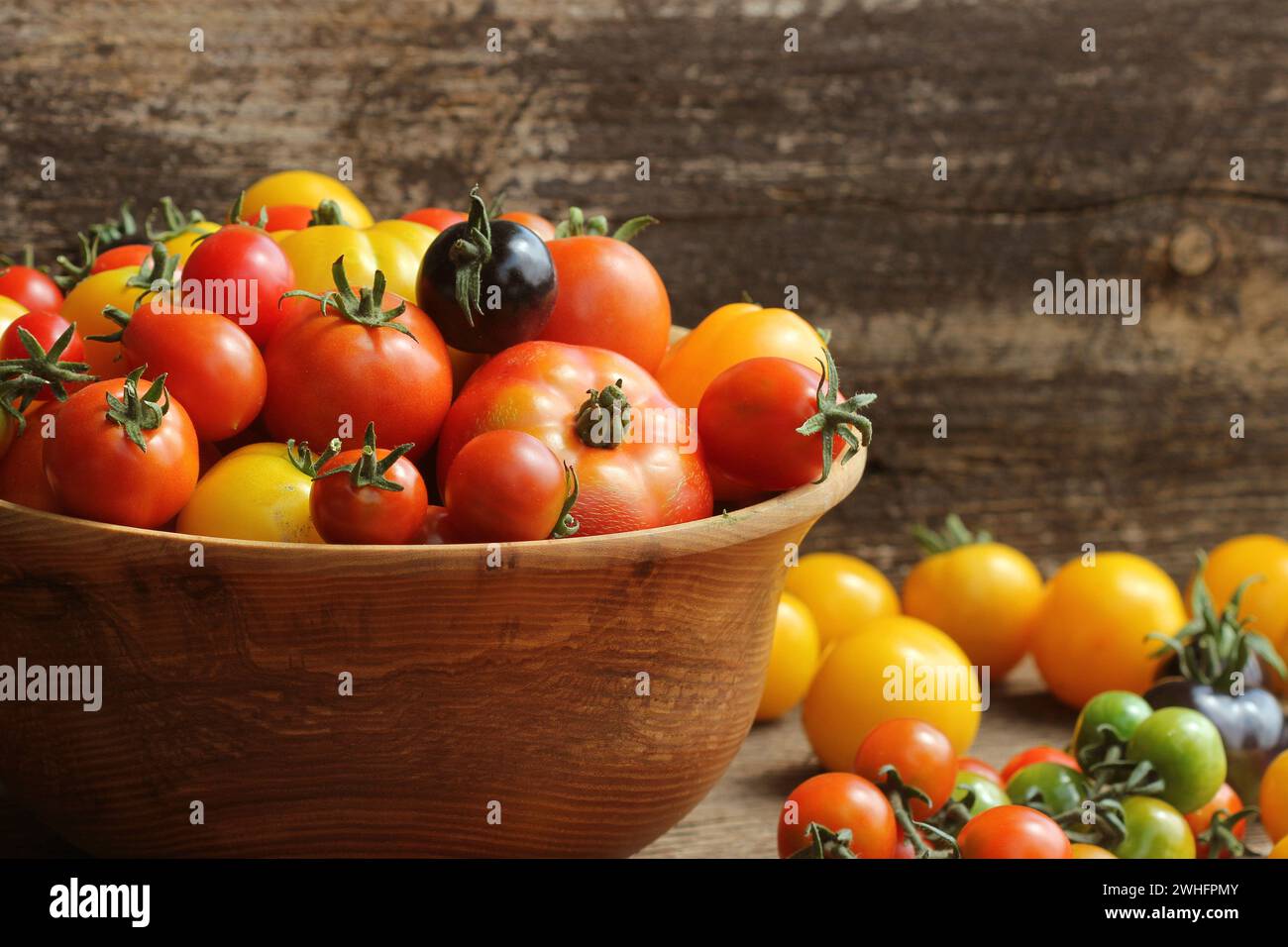 Hölzerne Schüssel mit frischem Wein gereift heirloom Tomaten aus Farmers Market Stockfoto
