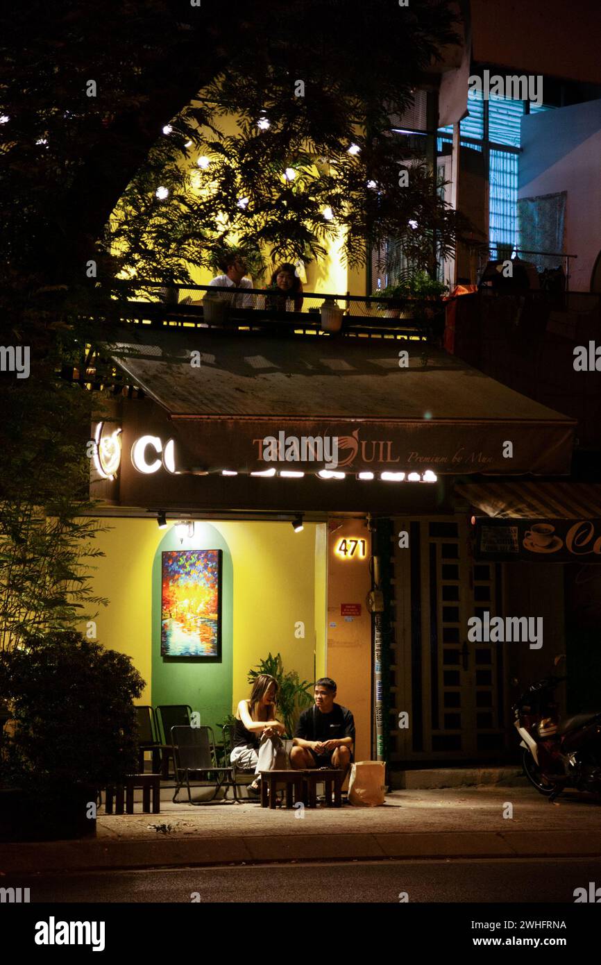Ho-Chi-Minh-Stadt, Vietnam - 2. Februar 2024: Zwei Paare bei einem Date in einem Straßencafé am Abend. Junge asiatische Leute sitzen und reden in einem Coffeeshop Stockfoto