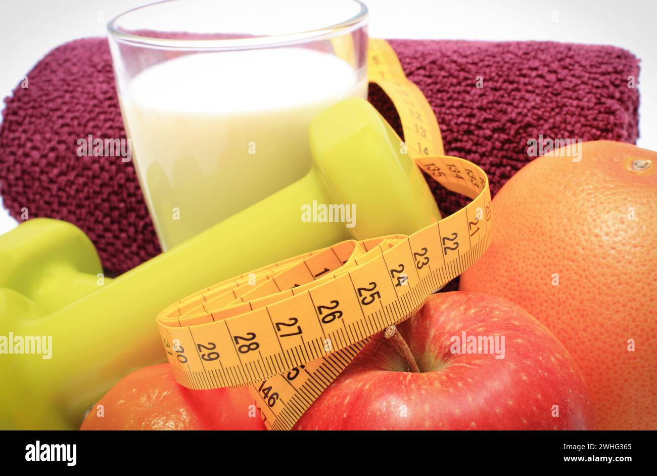 Maßband, frische reife Früchte und Kurzhanteln mit in Fitness. Abnehmen, gesunde Ernährung und sportliche Lebensstile Stockfoto