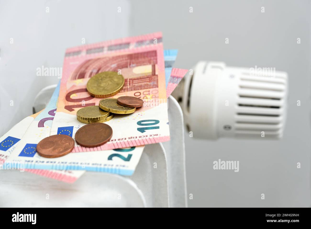 Euro-Banknoten und -Münzen auf Heizkörper, Konzept für steigende Energiepreise und Inflation, Kopierraum, ausgewählter Schwerpunkt Stockfoto