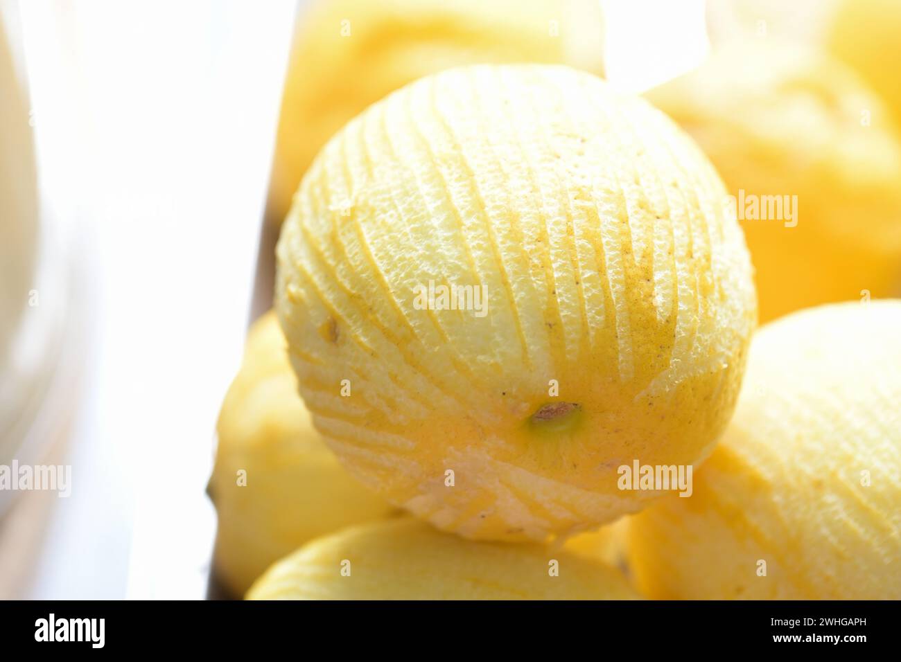 Zitronenfrucht mit Streifen entfernter Schale für Zesten, Kopierraum, ausgewählter Fokus Stockfoto