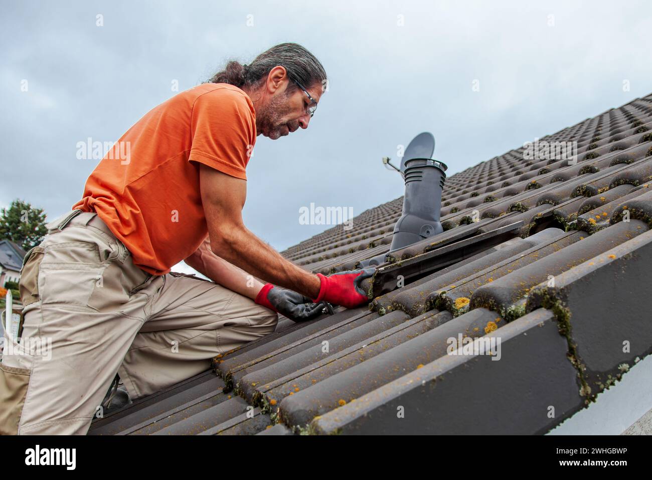 Dachdecker, Arbeiter auf dem Dach. Dacharbeiten. Gekacheltes Dach offen. Erster Schritt zur Vorbereitung auf Solar Stockfoto