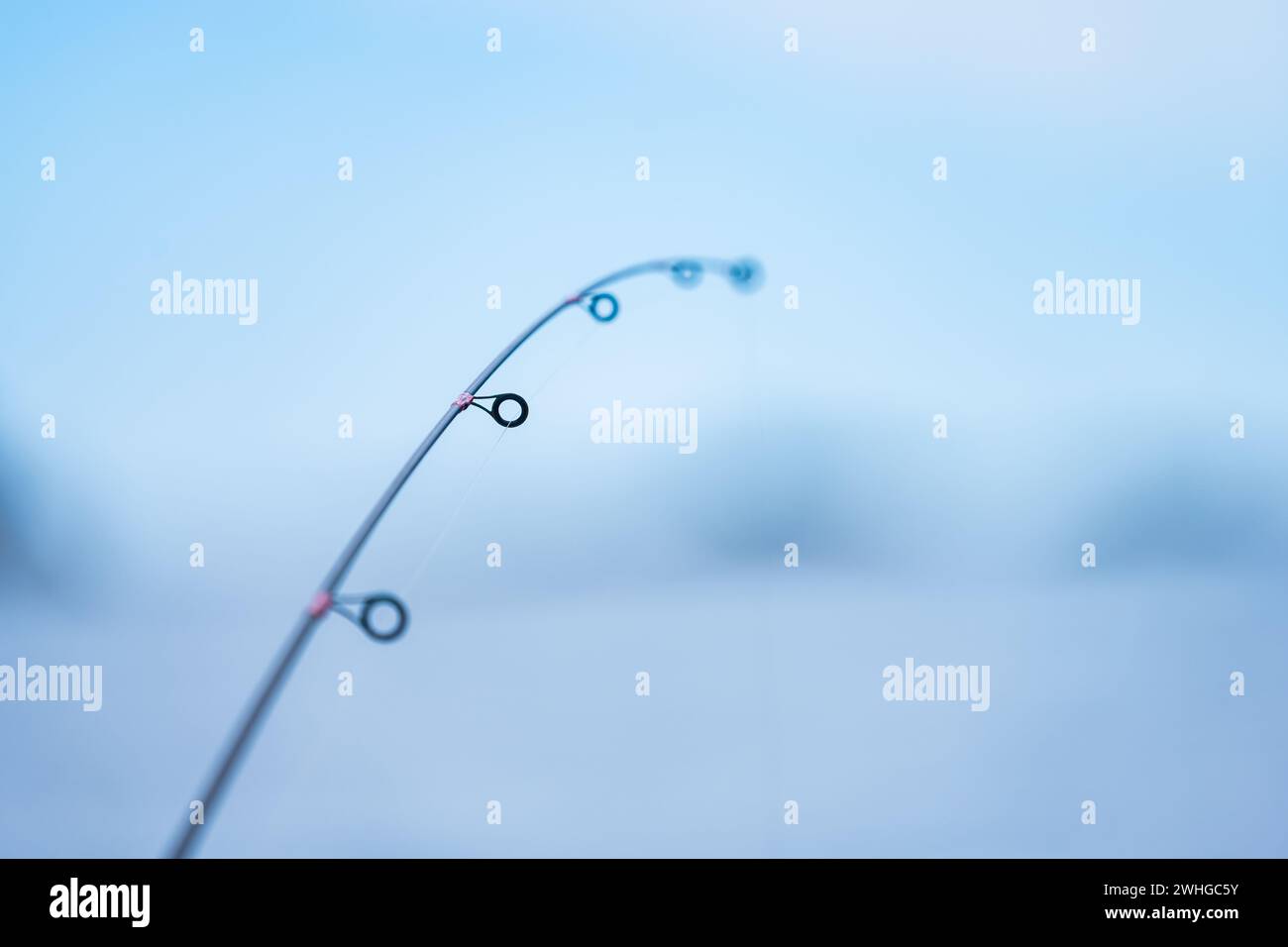 Die Angelstange wird leicht von einem Fisch am Haken gebogen Stockfoto