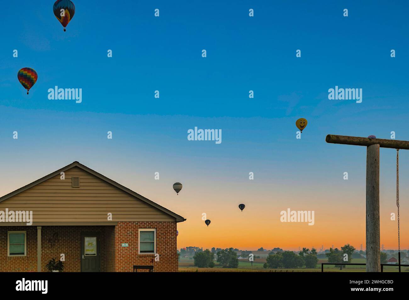 Start von Heißluftballons bei Sonnenaufgang am Vormittag während eines Ballonfestivals Stockfoto