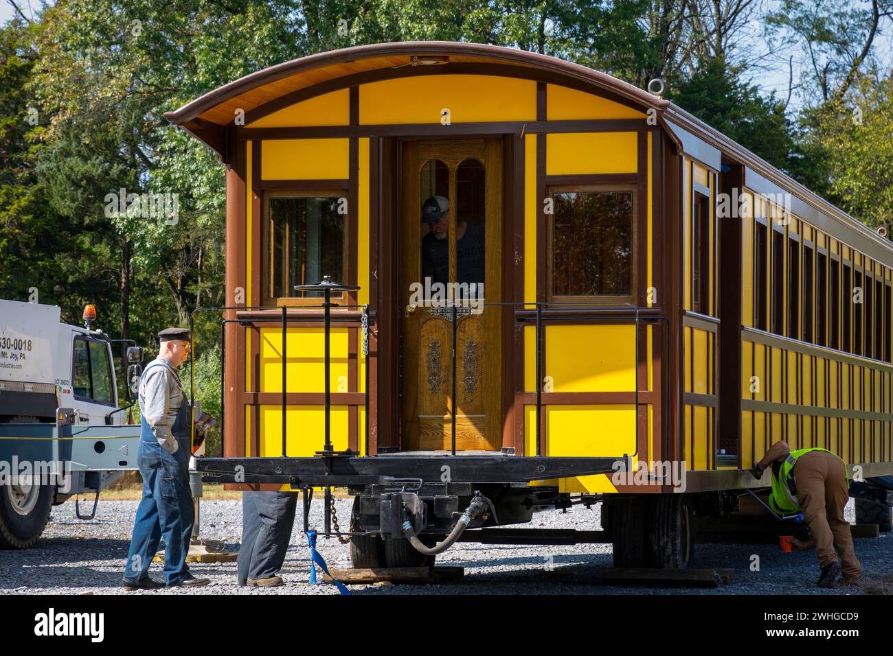 Einbau eines neuen gelben Reisezugwagens auf einer Eisenbahnstrecke Stockfoto