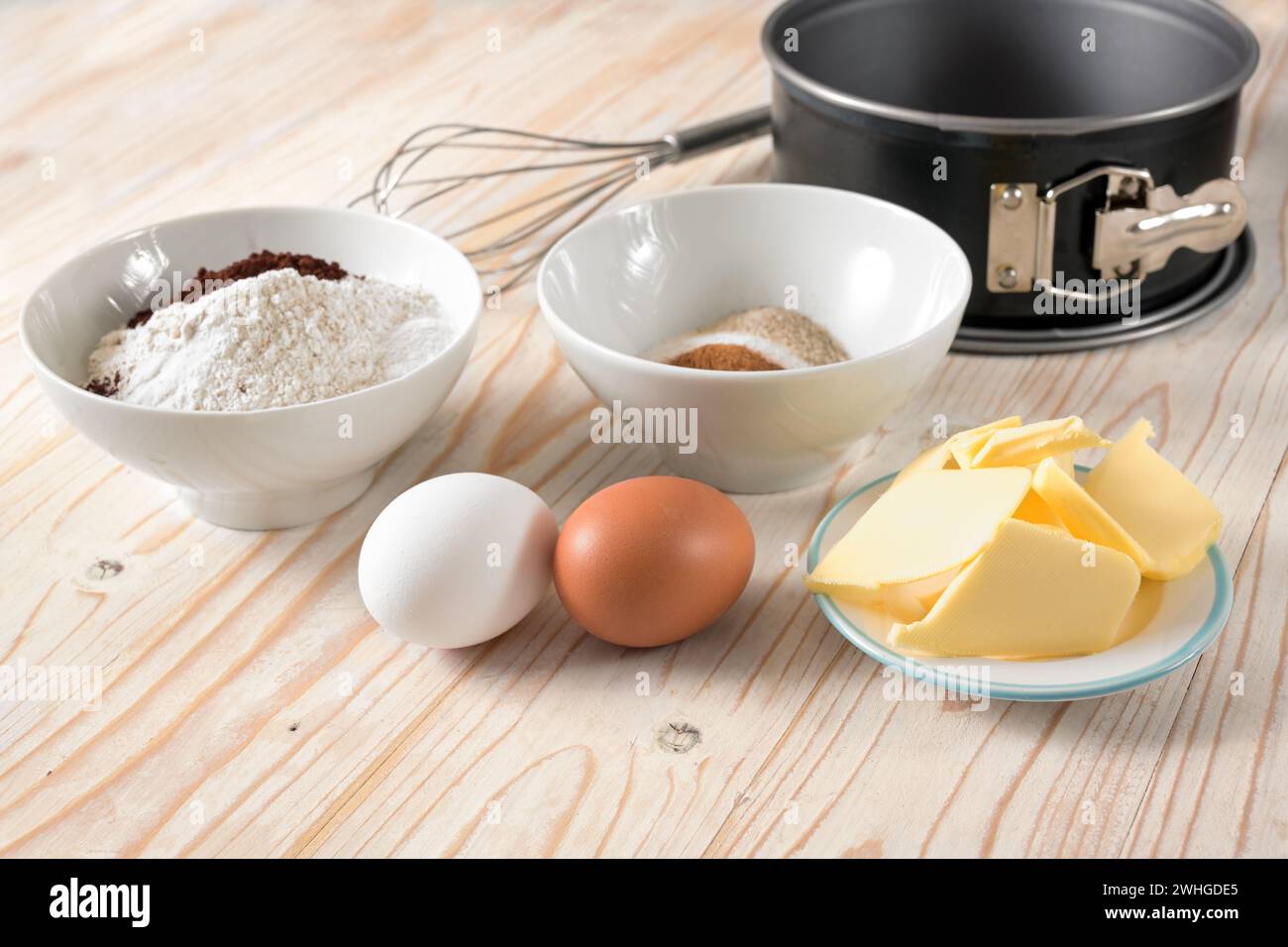 Zutaten für einen Kuchen wie Mehl, Eier, Butter und Zucker auf einem Holztisch, Backkonzept zu Hause, Kopierraum, ausgewählter Fokus, Stockfoto