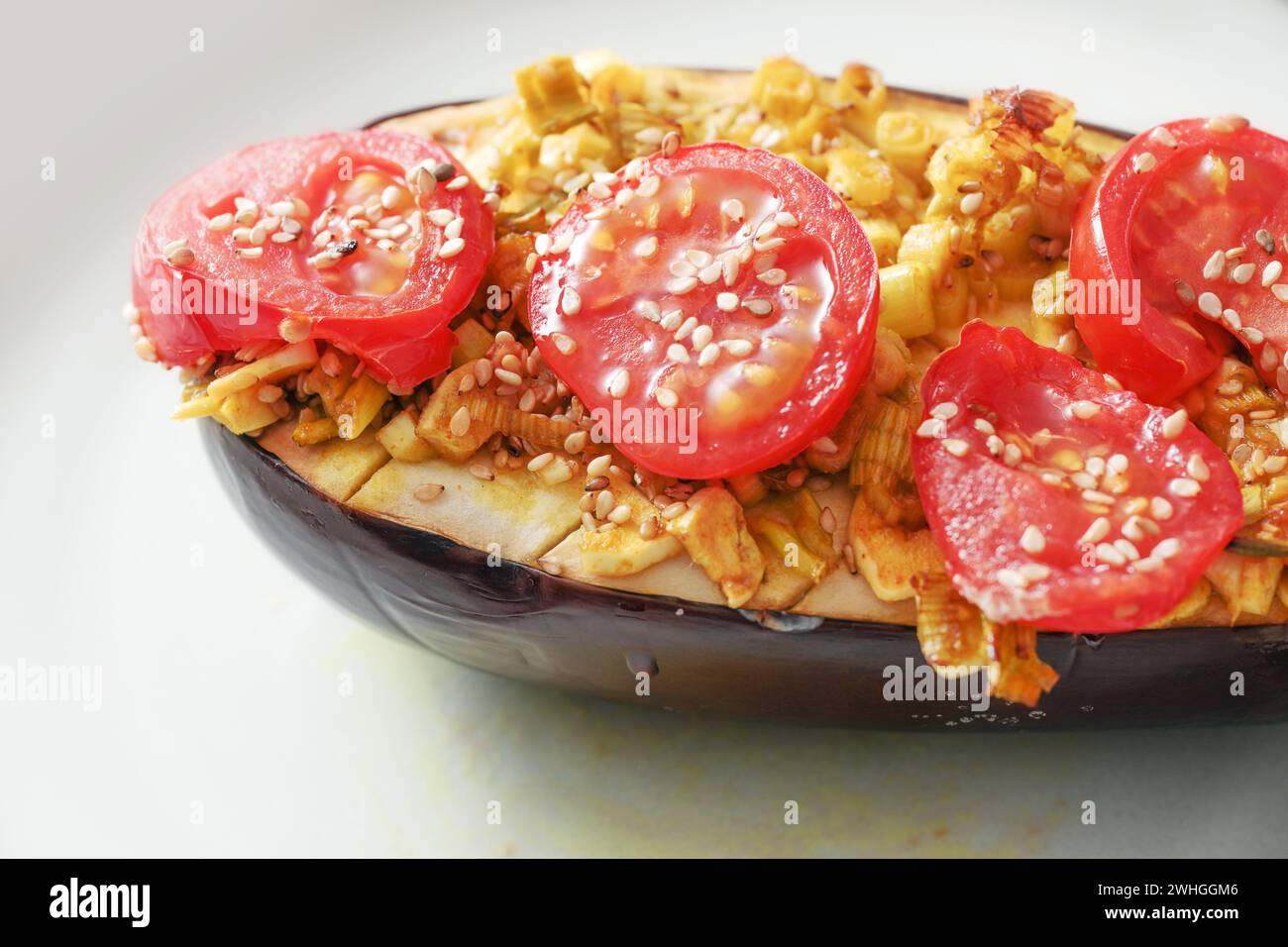Auberginen aus dem Ofen mit Platz, Zwiebeln, Tomaten und Sesamsamen, gesunde vegetarische Low Carb Mahlzeit, ausgewählter Fokus Stockfoto
