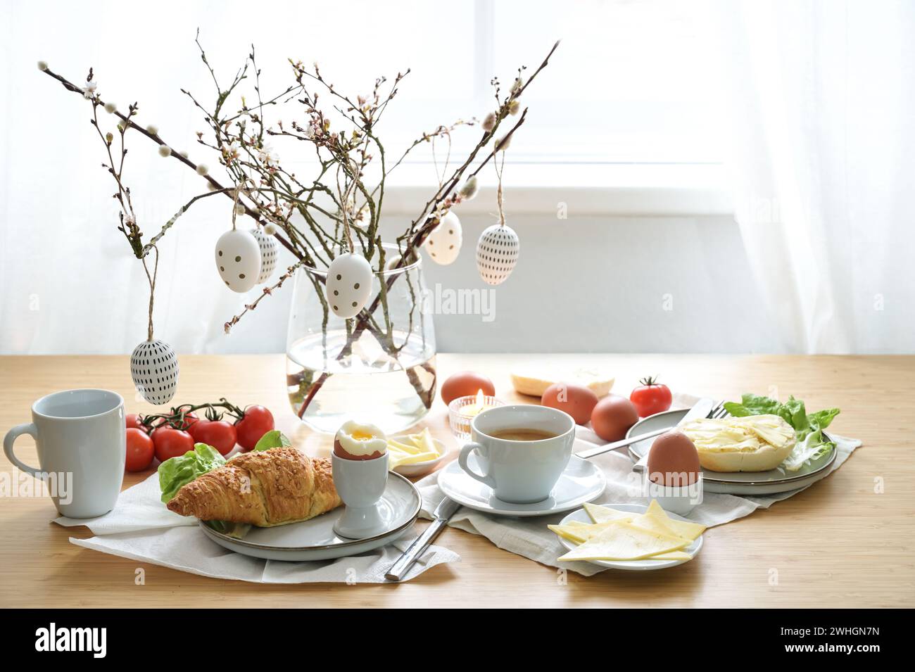 Frühstück oder Brunch mit Ostereierdekoration auf einem hölzernen Esstisch, Ort für Frühlingsferien, Kopierraum, ausgewählt Stockfoto