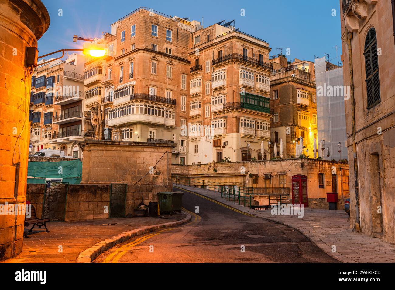 Valletta, Malta: Die traditionellen maltesischen Häuser mit Balkonen und Wänden von Valletta, die vor Sonnenaufgang beleuchtet sind Stockfoto