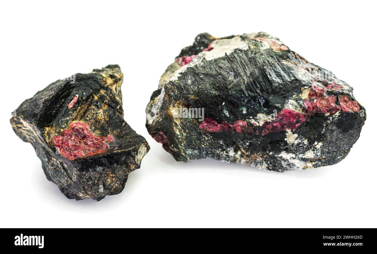 Zwei Gesteinsstücke, durchsetzt mit dem Mineral Eudialyt auf weißem Hintergrund Stockfoto