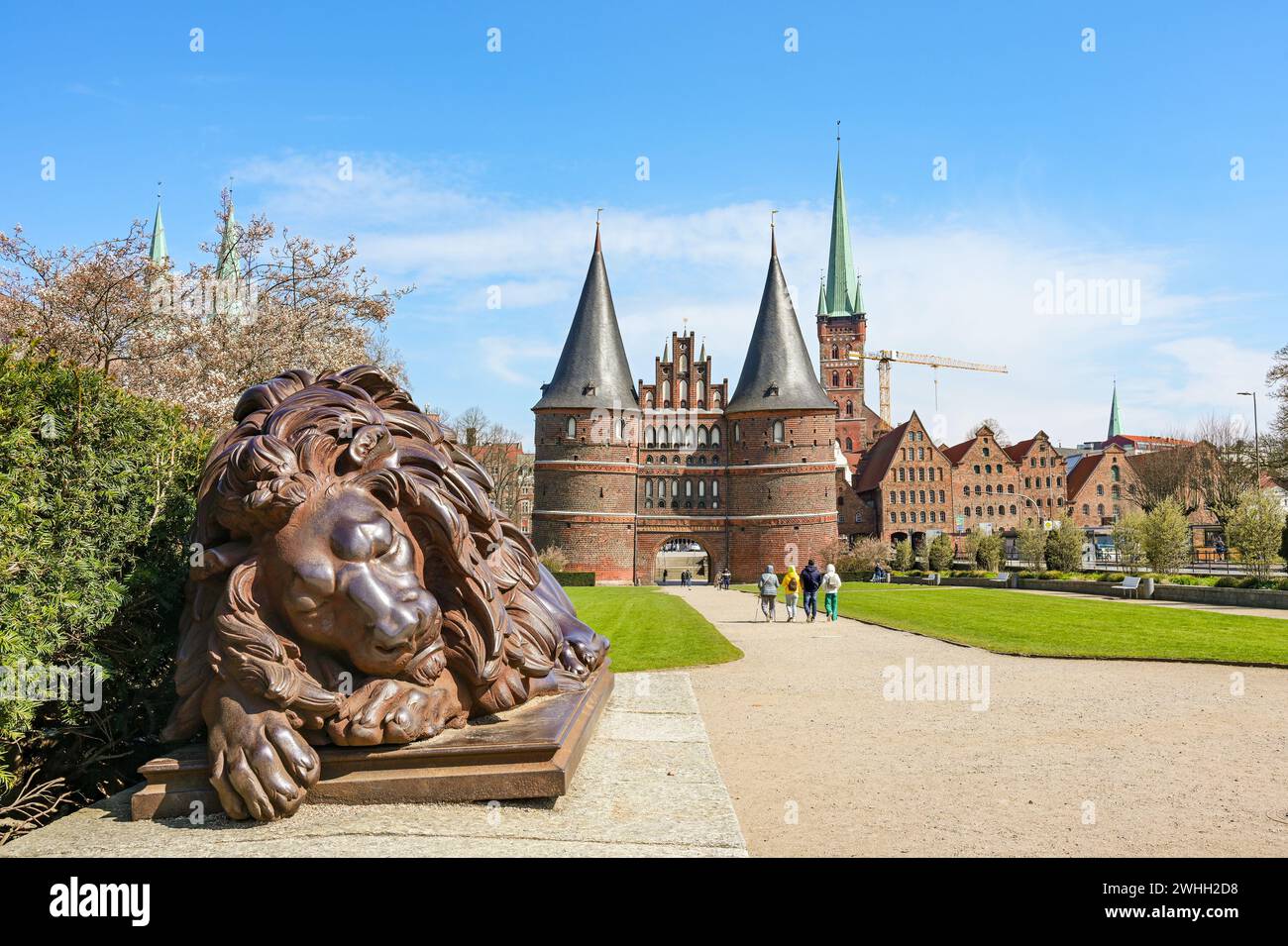Schlafende Löwenskulptur aus Eisen vor dem Lubecker Holstentor oder Holstentor, historisches Wahrzeichen und Touristenziel u Stockfoto