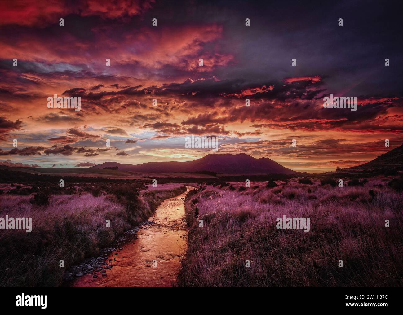 Sonnenaufgang bricht über den Bergen von Southland, Südinsel, Neuseeland. Stockfoto