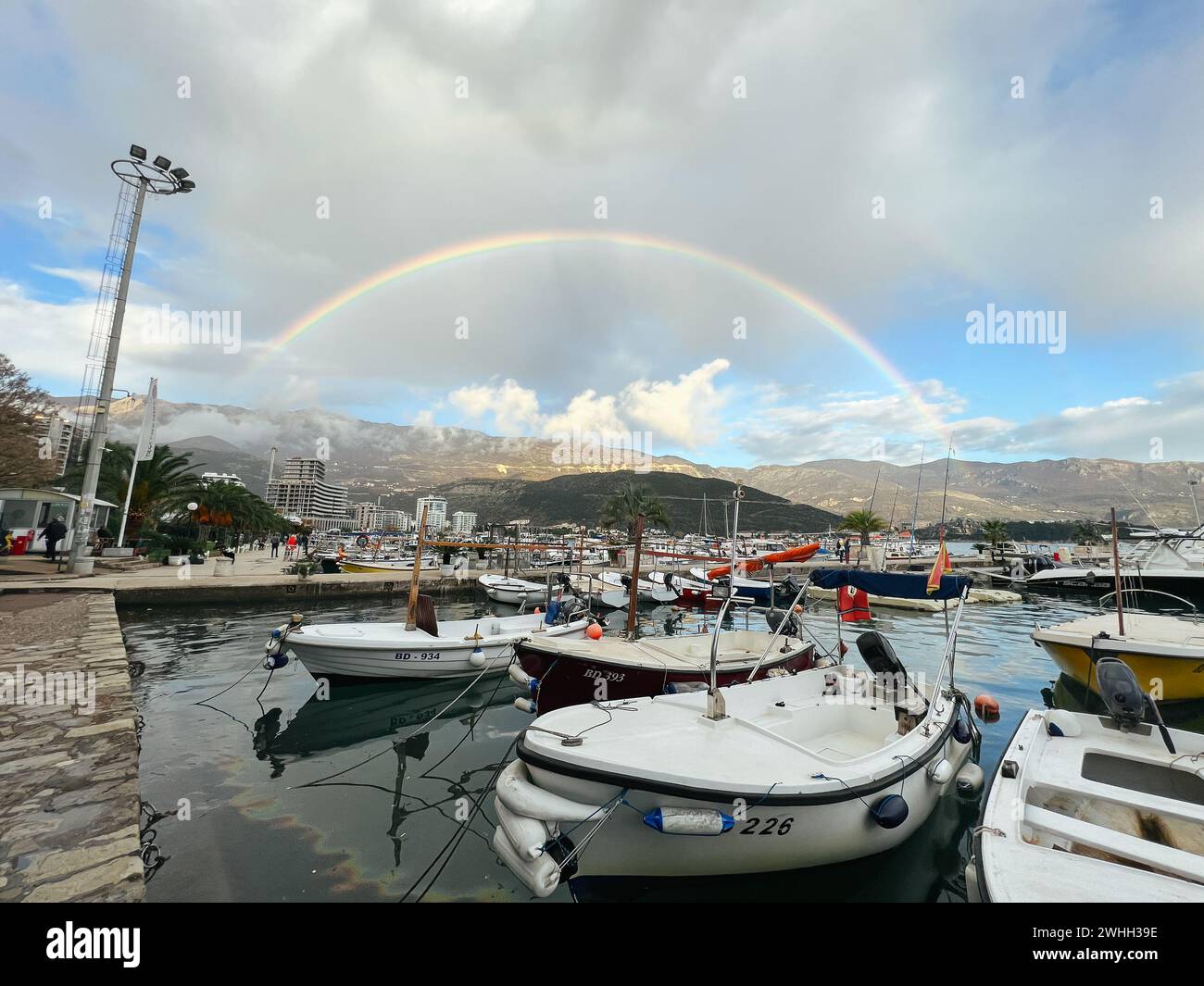 Yachten vor dem Hintergrund eines Regenbogens über den Bergen am Pier vor Anker Stockfoto