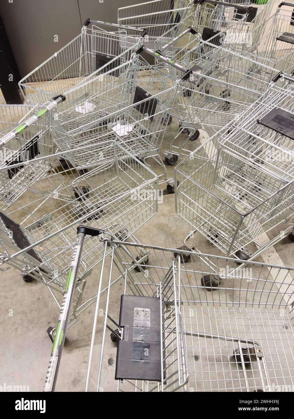 Supermarkt-Wagen stehen in Unordnung auf dem Ladenboden Stockfoto