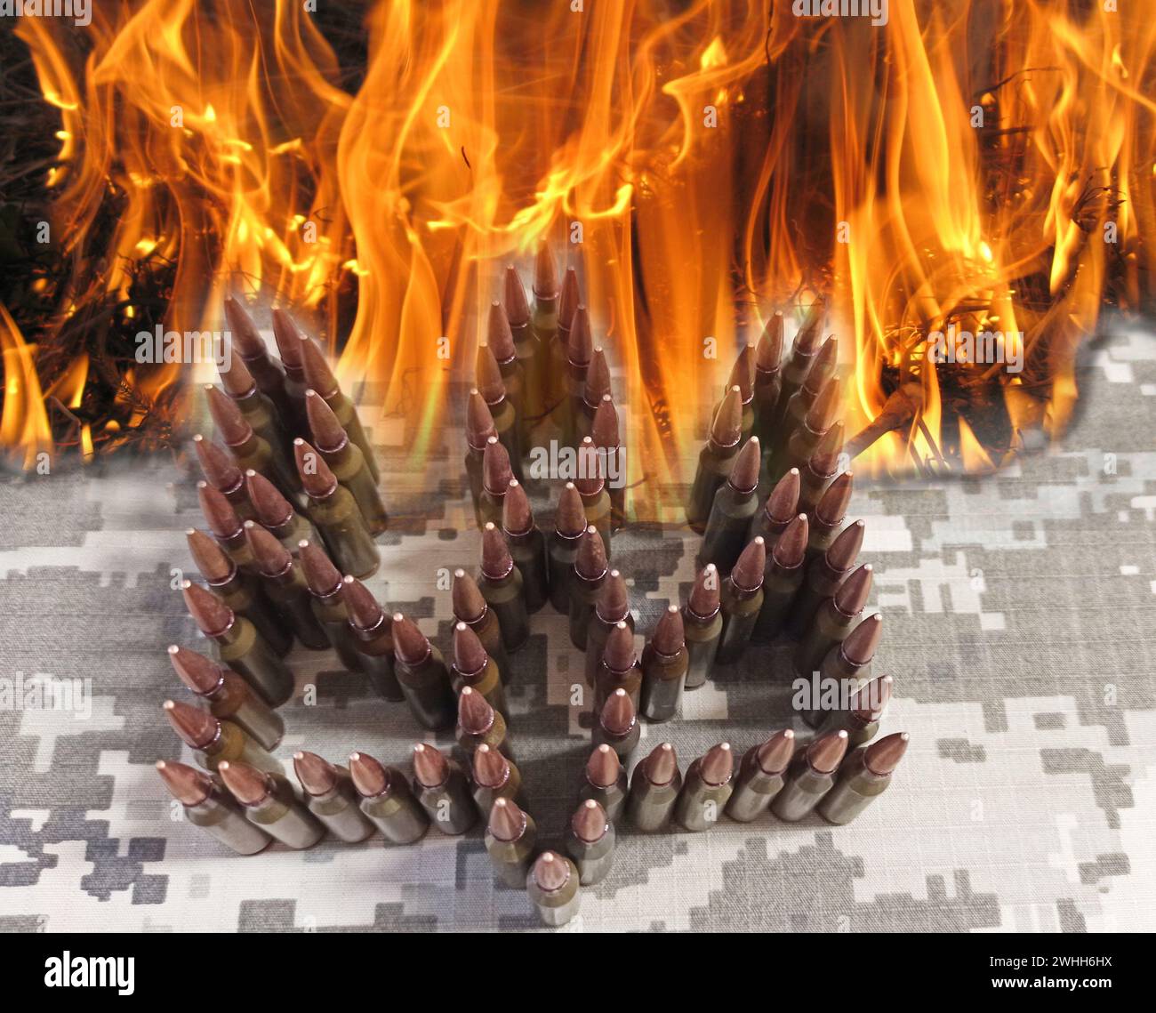 Ukrainisches Wappen von Patrons im Feuer. Krieg in der brennenden Ukraine. Russischer Angriff auf die Ukraine. c Stockfoto