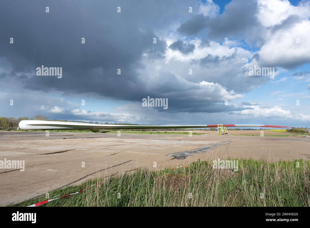 Rotorblatt einer Windkraftanlage, die in der Nähe des geplanten Installationsstandorts abgestellt ist, Vorbereitung auf den Bau einer erneuerbaren Energiequelle Stockfoto