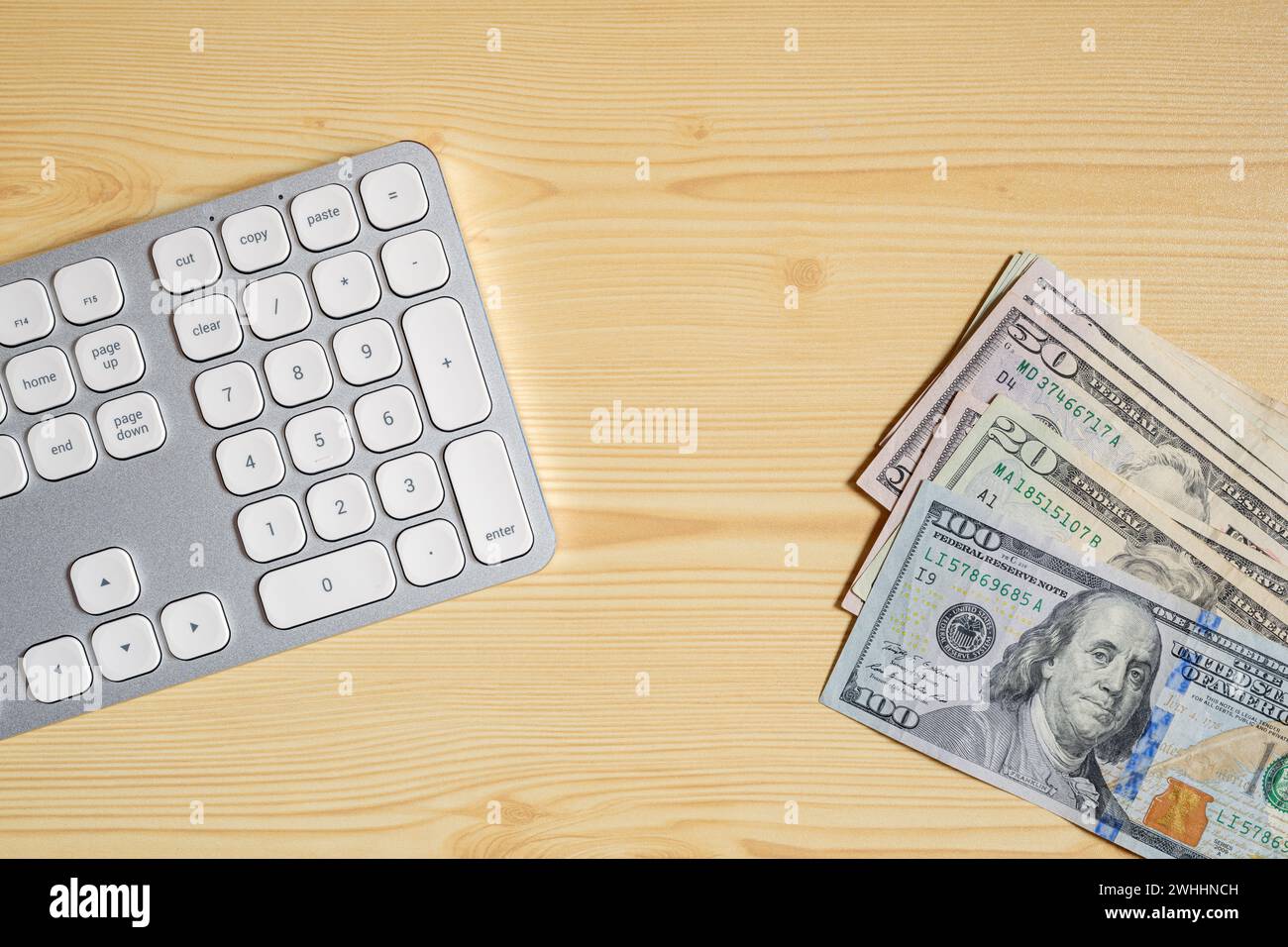 Desktop-PC-Computertastatur und Geldscheine in US-Dollar am Schreibtisch, Draufsicht Stockfoto