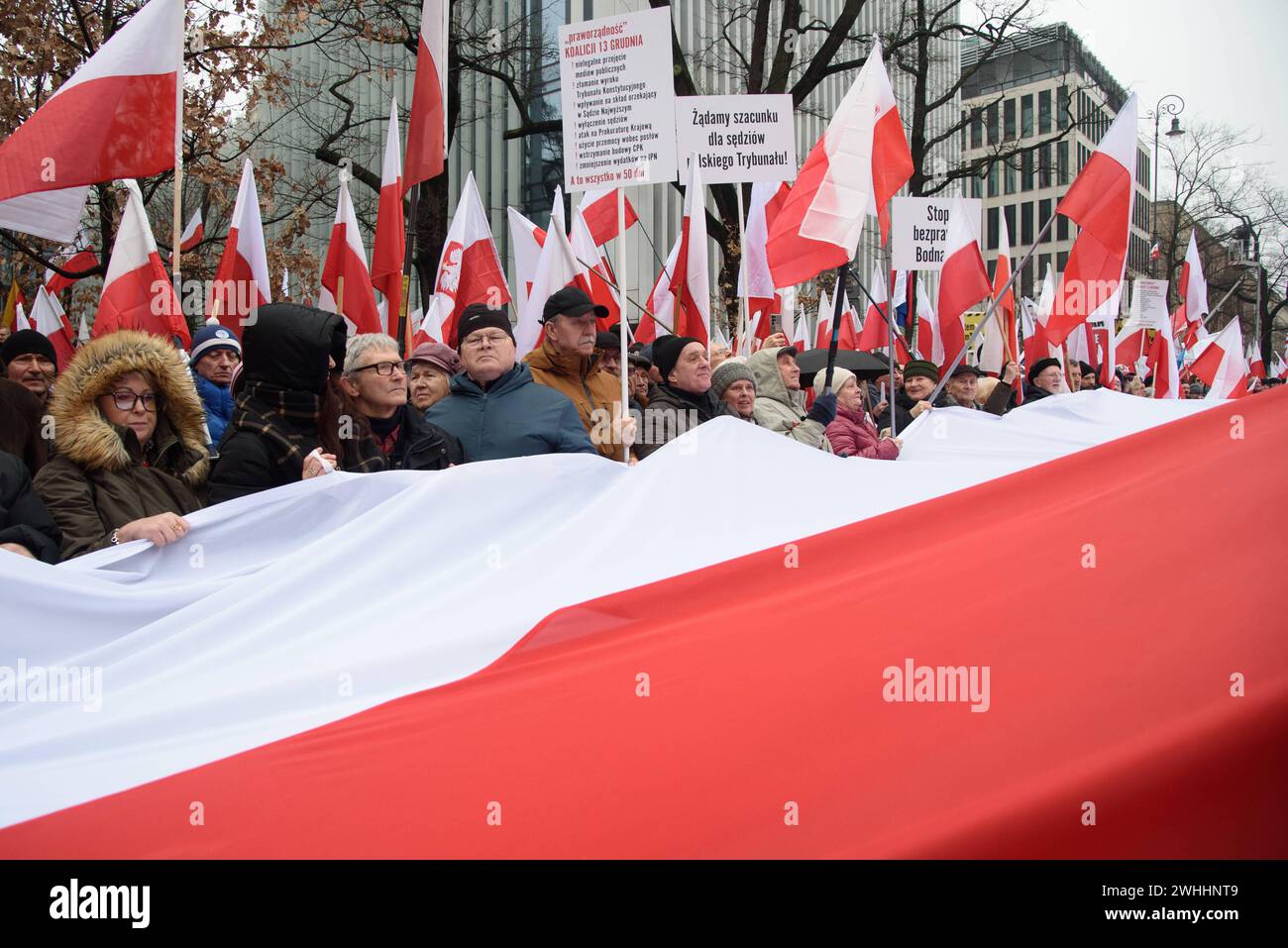 Protest Gegen Die Regierung In Warschau. Die Menschen halten Polens Nationalflaggen, während sie am 10. Februar 2024 an einem Protest gegen die Regierung in Warschau, Polen, teilnehmen. Mehrere Hunderte Anhänger der Partei für Recht und Gerechtigkeit der PiS versammelten sich vor dem Verfassungsgericht in Warschau zu einem anti-staatlichen Protest gegen die Regierungskoalition unter der Führung des pro-europäischen Donald Tusk. Warschau Polen Copyright: XAleksanderxKalkax Stockfoto