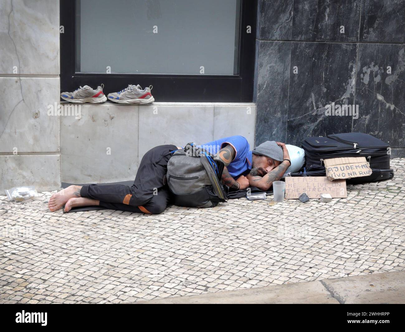 Obdachloser Mann, der auf der Straße in Lissabon schläft und um Geld bittet, um zu überleben Stockfoto
