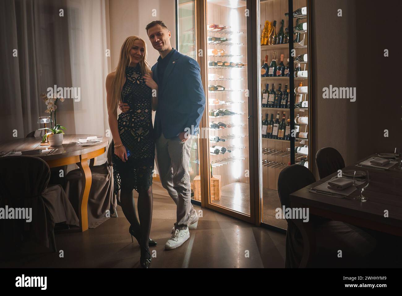 Raffiniertes Paar in einem Resort-Speisesaal mit Weinschränken Stockfoto