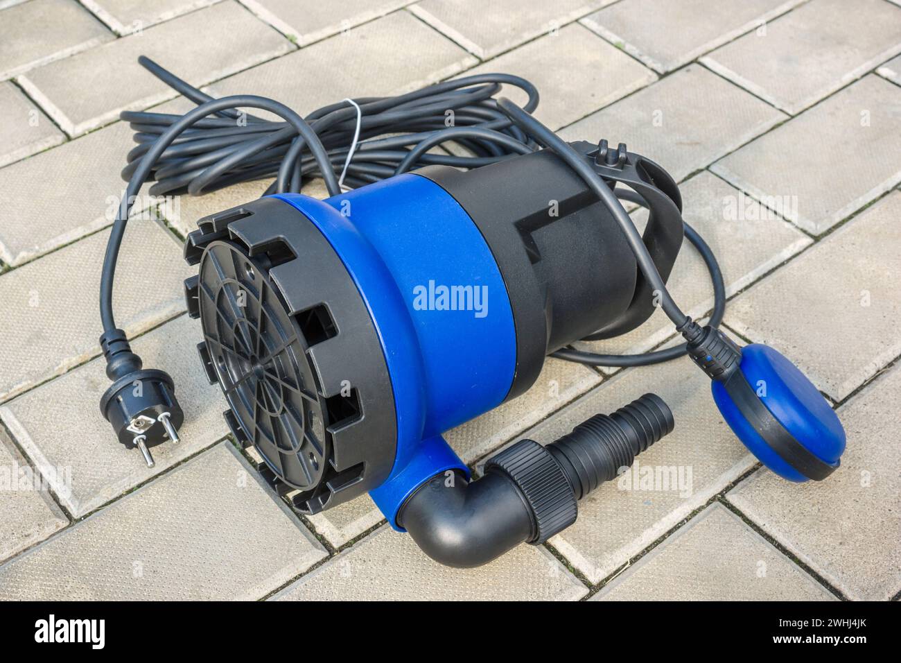 Elektrische Tauchpumpe mit blauem Kunststoffgehäuse auf Steinboden Stockfoto