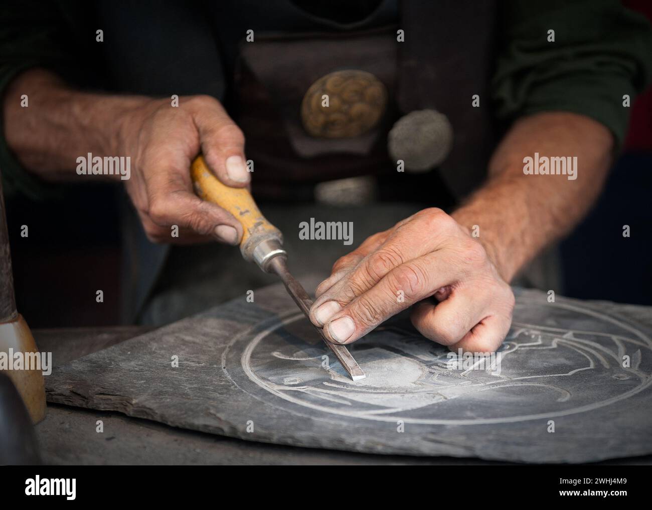 Handwerker arbeiten an einem Schieferteller Stockfoto