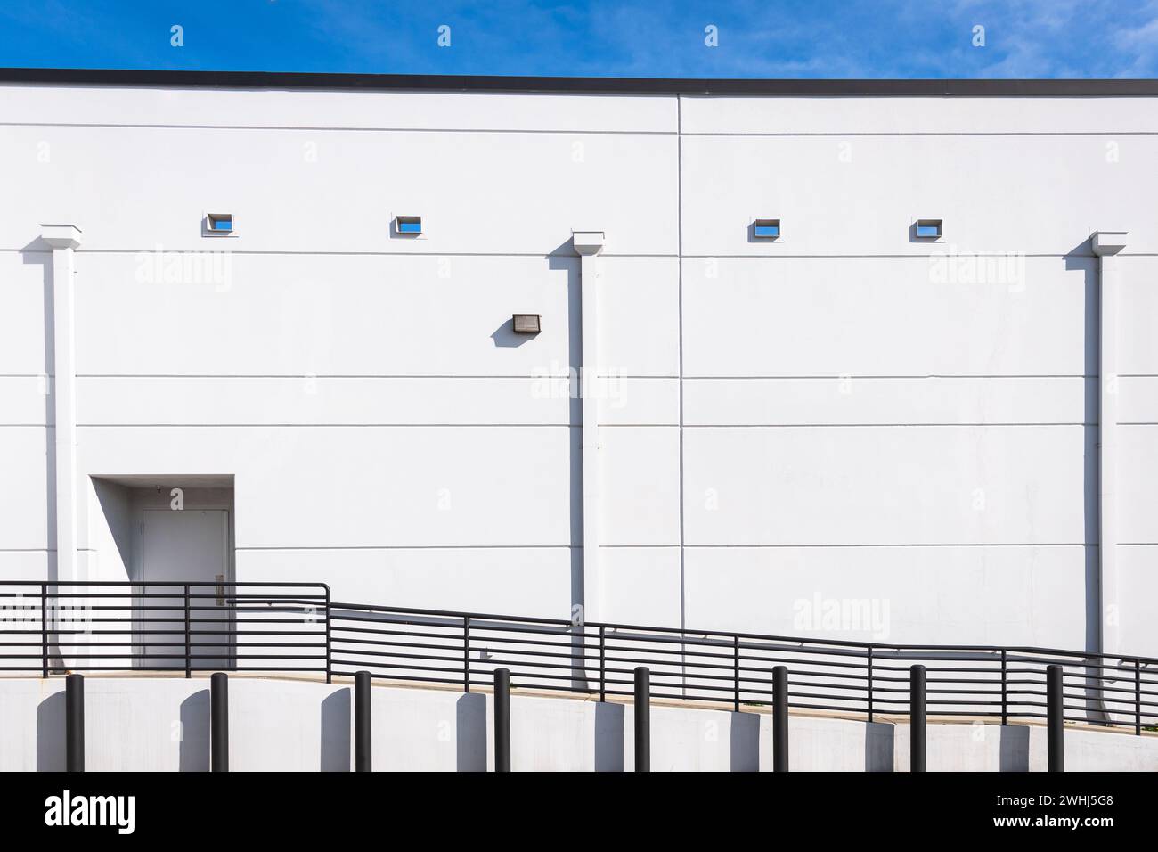 Weiße Wand, Rampe, schwarzes Geländer und Pylonen Stockfoto