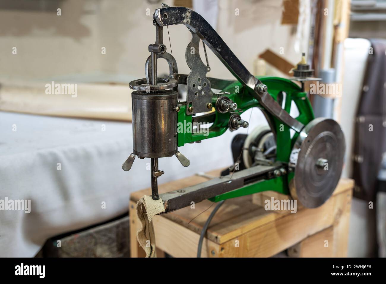 Industrielle Nähmaschine für Lederarbeiten mit Schwungrad und rotierendem Nähfuß in der Handwerkstatt, für Taschen verwendet, Stockfoto