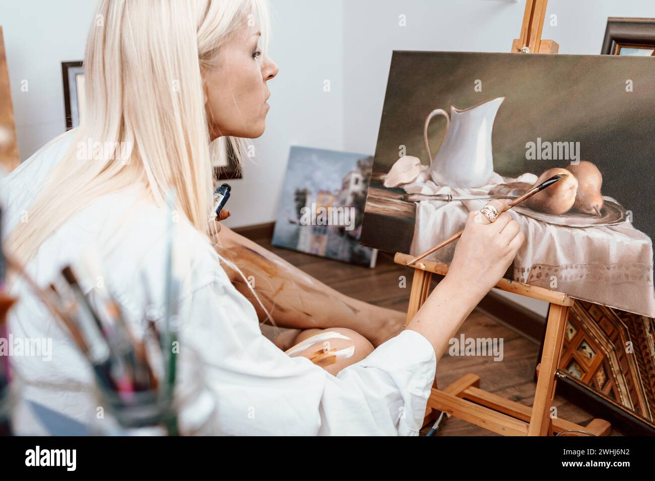 Junge blonde Malerin in ihrem Atelier Stockfoto