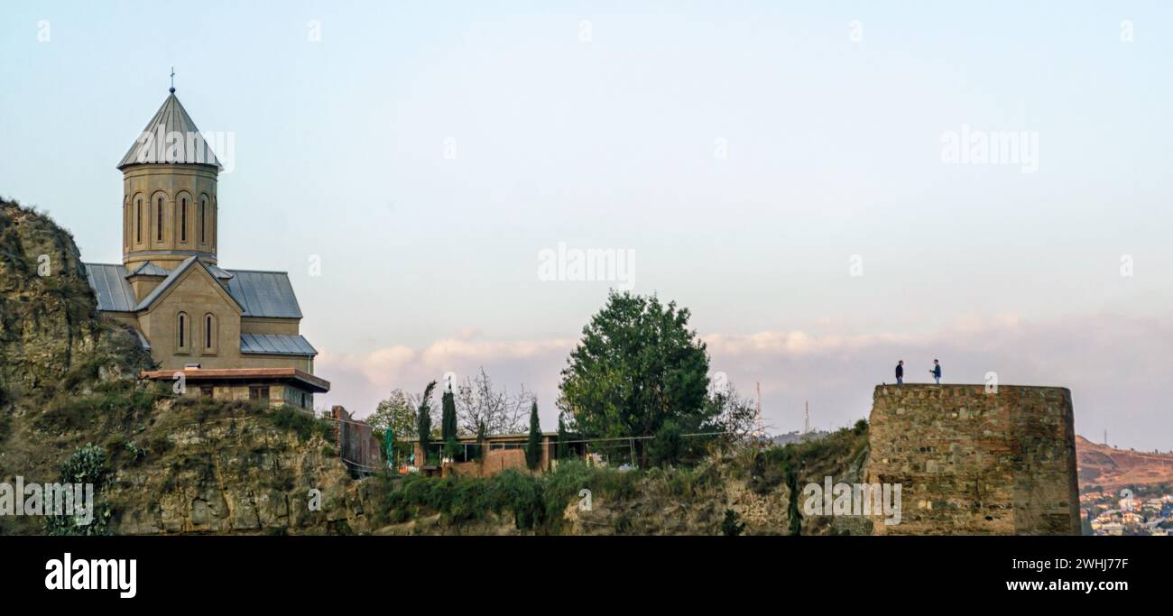 Christliche Kirche auf dem Berg und die alte antike Festung vor dem Hintergrund des Stadtbildes Stockfoto