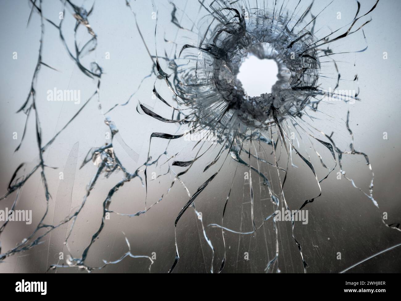 Schussloch in zerrissenem Fensterglas Stockfoto