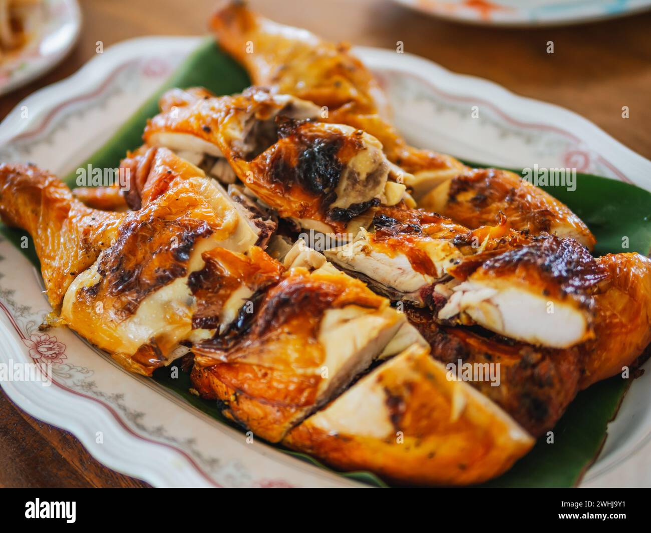 Hausgemachte Gai Yang, thailändisches gegrilltes Hühnchen. Gebratenes Hühnchen auf Bananenblättern. Knuspriges gegrilltes Hühnchen gilt als perfekte Kombination. Frittiert Stockfoto