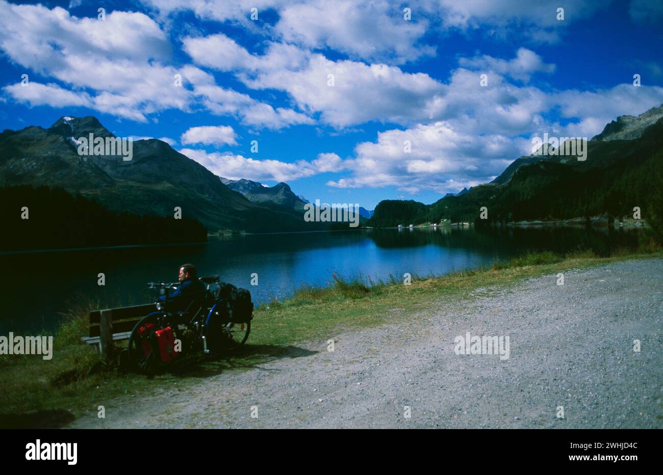 Ein Radfahrer rastet am Silvaplanersee mit Blick auf die Oberengadiner Berglandschaft am Silvaplaner See im Oberenga MACHT EIN Biker eine Pause Stockfoto