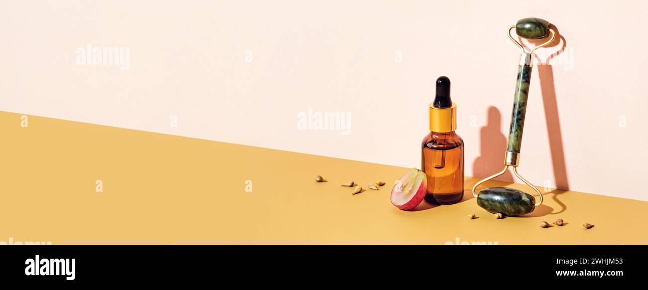 Banner mit Bio-Traubenkernöl-Kosmetik und Massageroller. Weinbereitung Ohne Abfall. Hautpflegemittel, diagonale Isomen Stockfoto