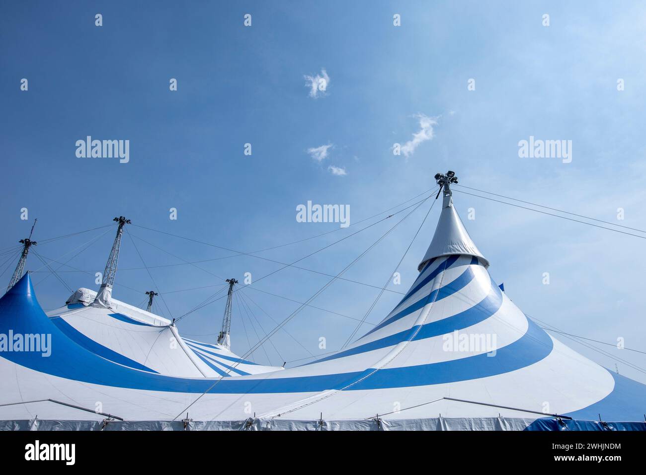 Großes blau-weißes Zirkuszelt unter sonnigem Himmel Stockfoto