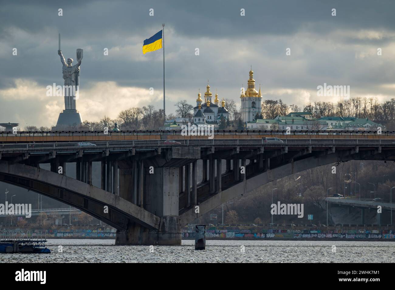 Rechts-Ufer-Kiewer Hügel mit U-Bahn-Brücke, Pecherska lavra-Kloster, Mutterland-Denkmal und ukrainischer Flagge. Blick auf die Stadt Kiew. Stockfoto