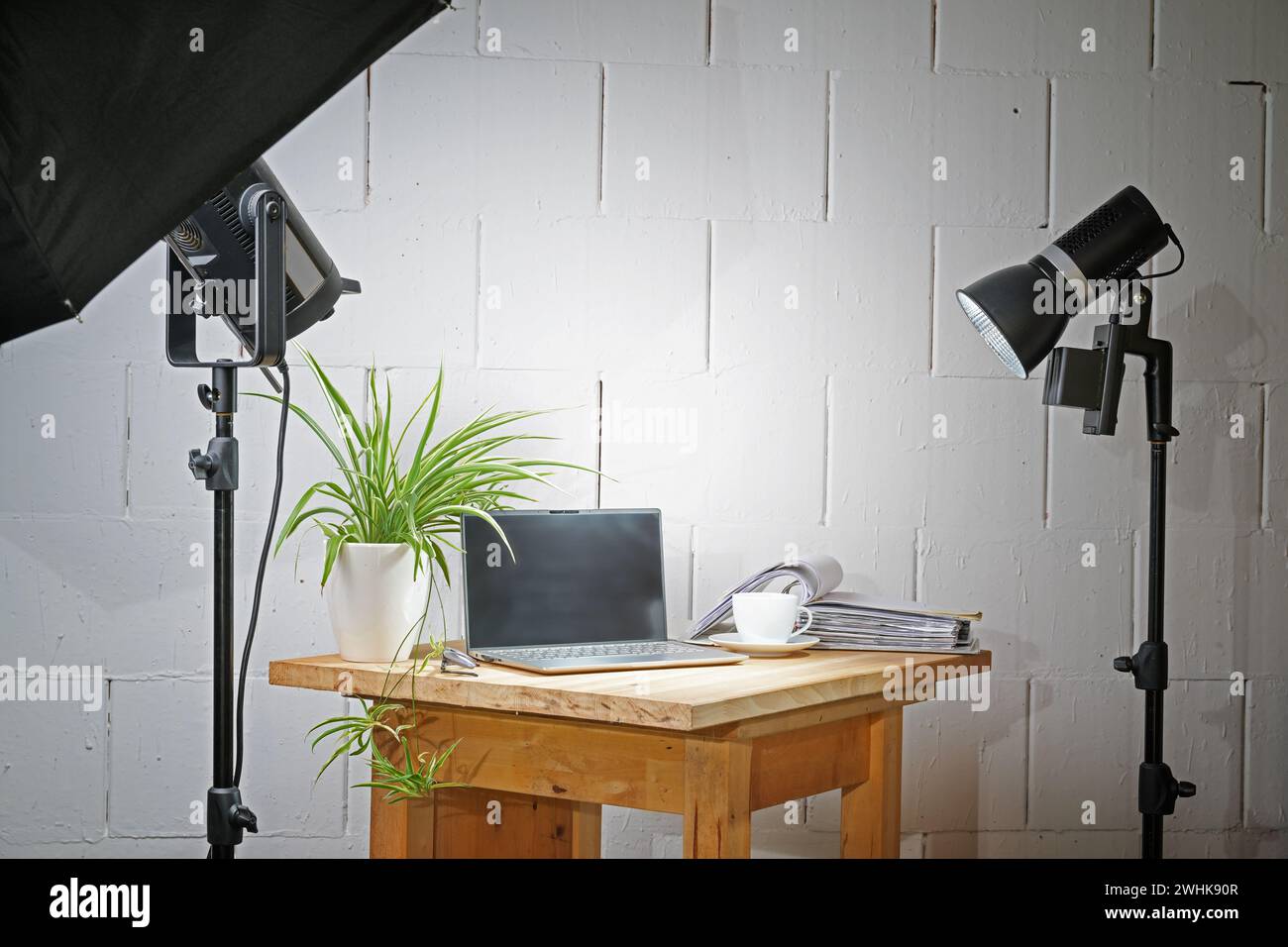 Kleines Fotostudio mit Tischplatte in einer Garage mit einem Holzbrett für die Objekte, Leuchten und Ständer, Konzept für kreatives Geschäft A Stockfoto