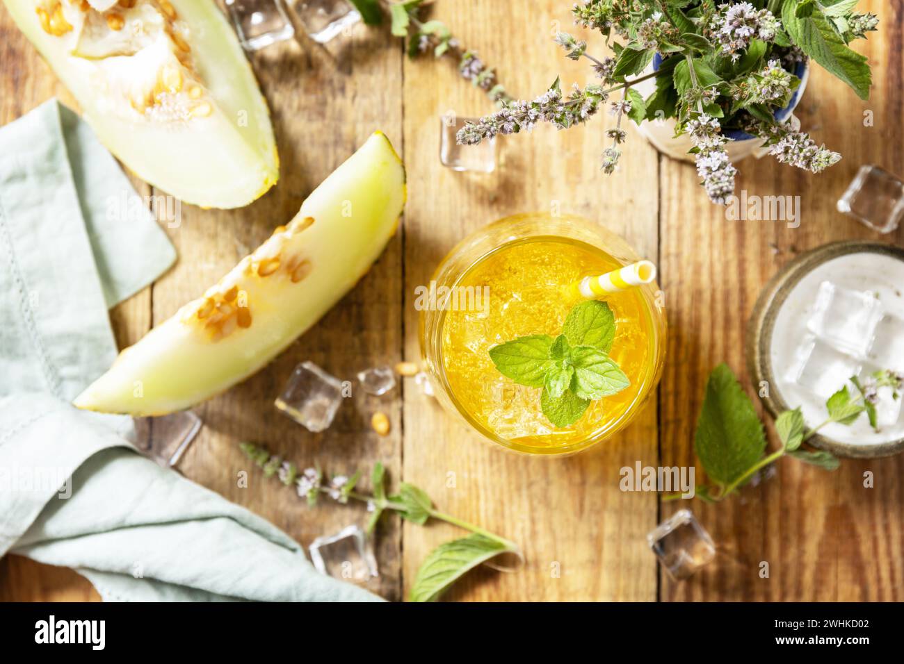 Frische, erfrischende, fruchtige Sommergetränke, saisonale Getränke. Melonenlimonade in Gläsern mit Eis und Minze auf einem rustikalen Holztisch. Stockfoto