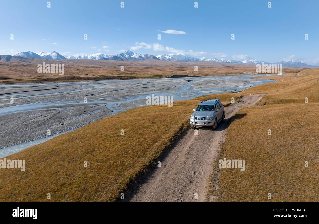 Geländefahrzeug auf Schotterpiste, Bergtal mit mäandernden Fluss, karge dramatische Berglandschaft, Tien Shan, Sary-Jaz, Kirgisistan Stockfoto