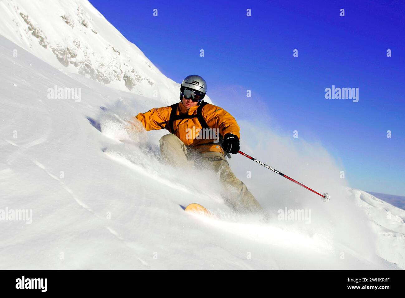 Skifahrer in Aktion, Abfahrt auf einer Piste, Tiefschnee Stockfoto