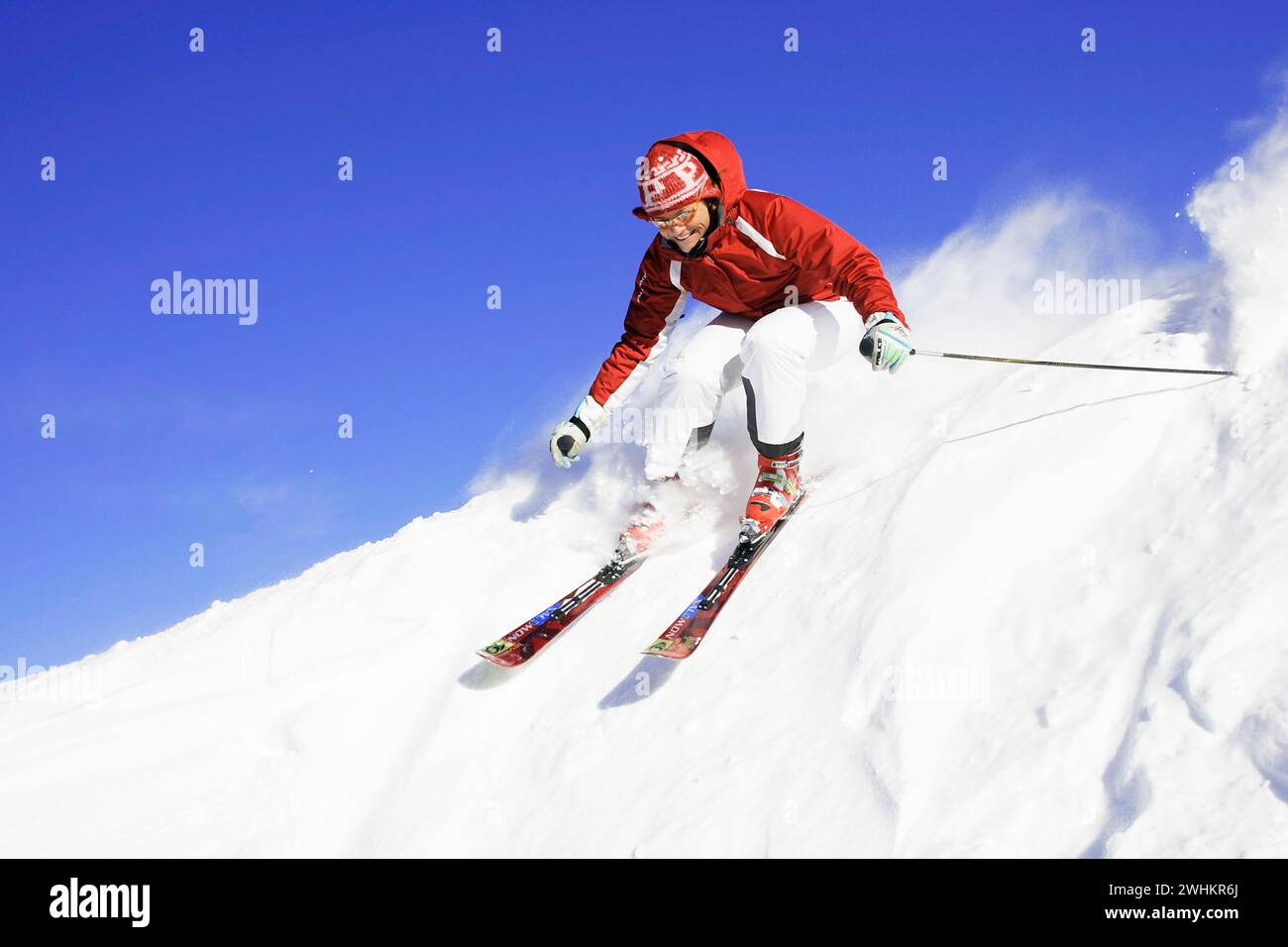 Skifahrer in Aktion, Abfahrt auf einer Piste, Tiefschnee Stockfoto