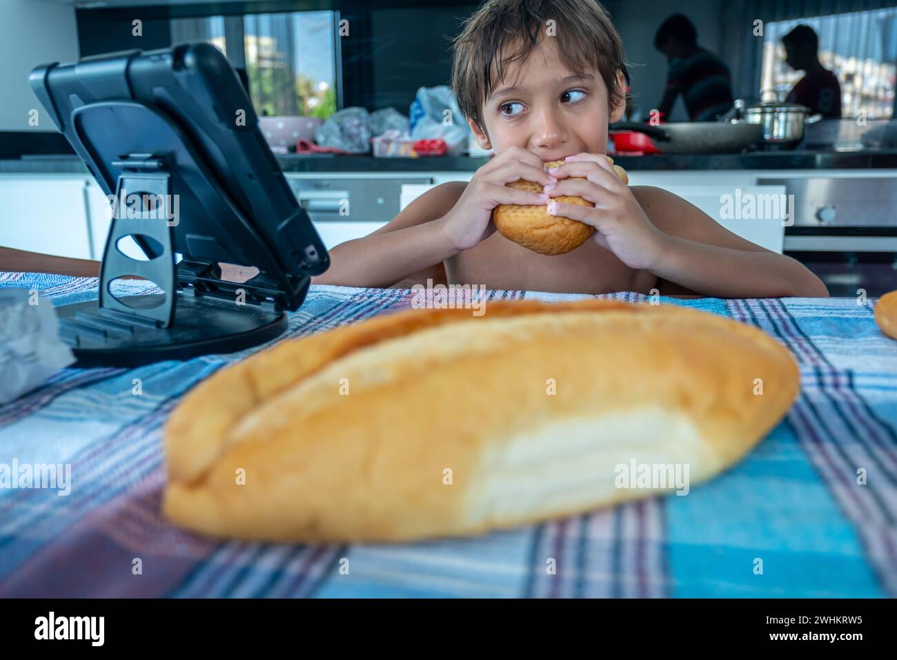 Junge isst Sandwich und schaut sich einen Film an Stockfoto