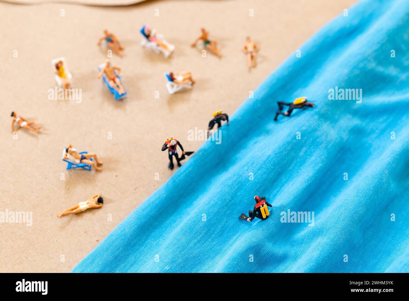 Eine winzige Person in einem Taucheranzug am Strand im Sommer Stockfoto
